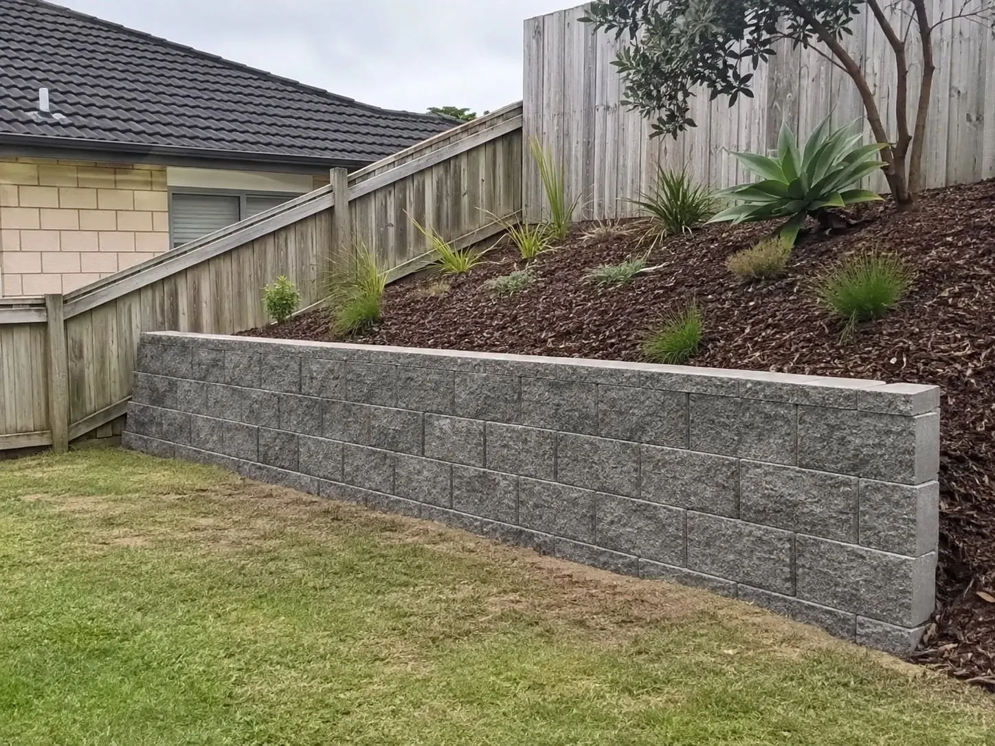 Segmental boundary retaining wall between new homes in Millwater, Auckland