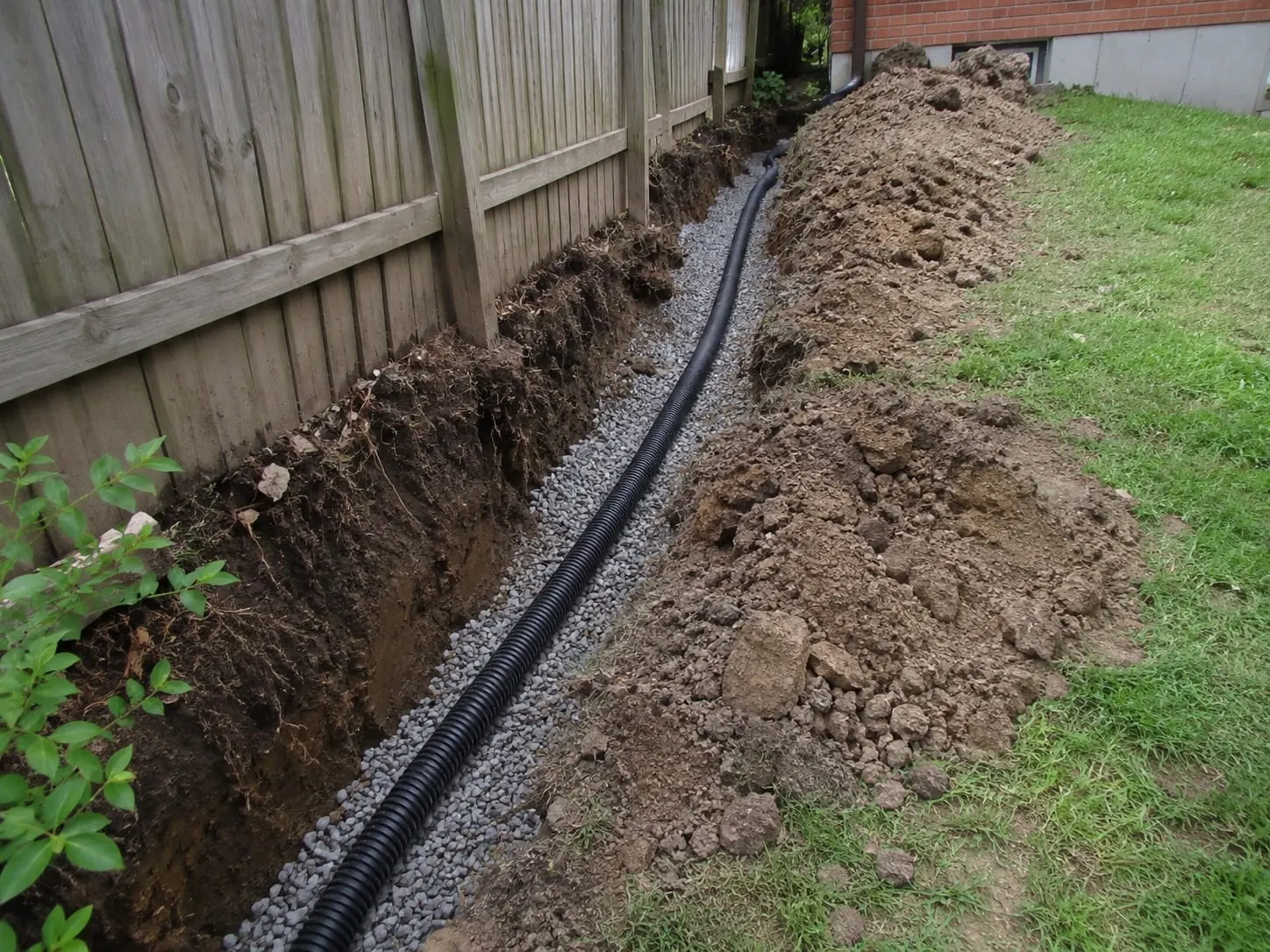 Perforated drainage pipe bedded in clean drainage metal